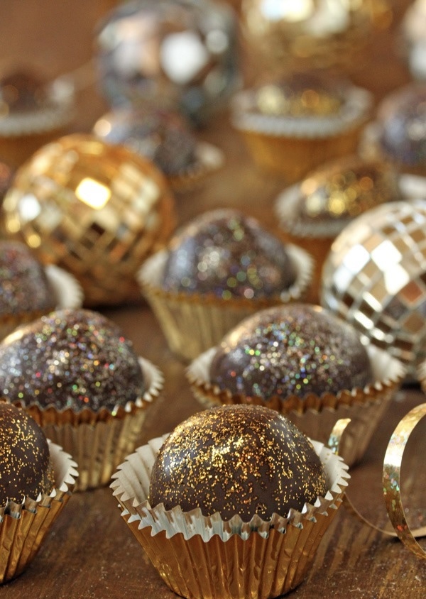 Sparkling chocolate disco ball truffles with gold glitter beside miniature mirrored disco balls for Foodie Kids New Year's Eve cooking camp